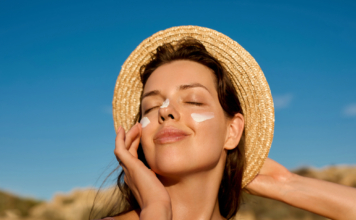 La guía de protector solar que necesitas antes de tus vacaciones de verano Protector solar SPF50+ aplicado en el rostro antes de unas vacaciones de verano para proteger la piel de los rayos UV.